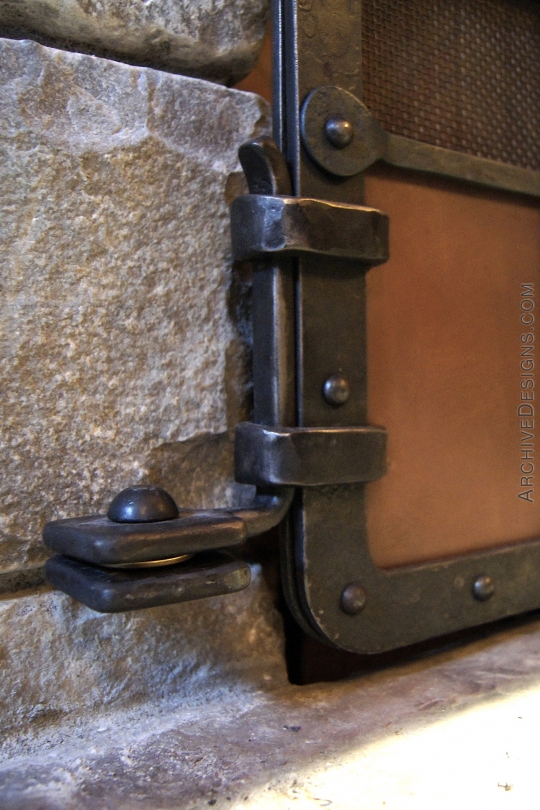 Close up of hinge detail on wrought iron fire screen with copper panels and trees in repoussé