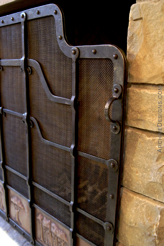 Handle of wrought iron fire screen with copper panels and trees in repoussé