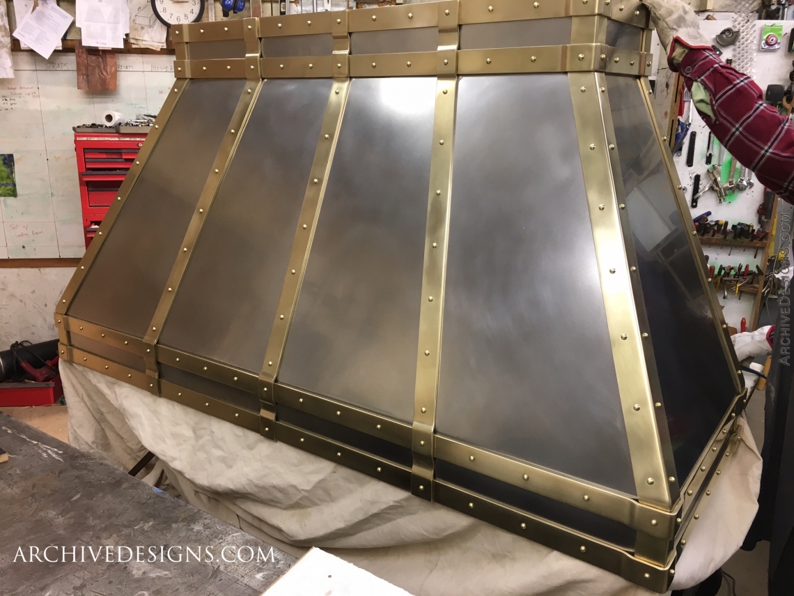 A burnished stainless & brass hood for a modern or traditional classic kitchen nearing completion in the shop. The burnished stainless has a more satin look than polished metal.